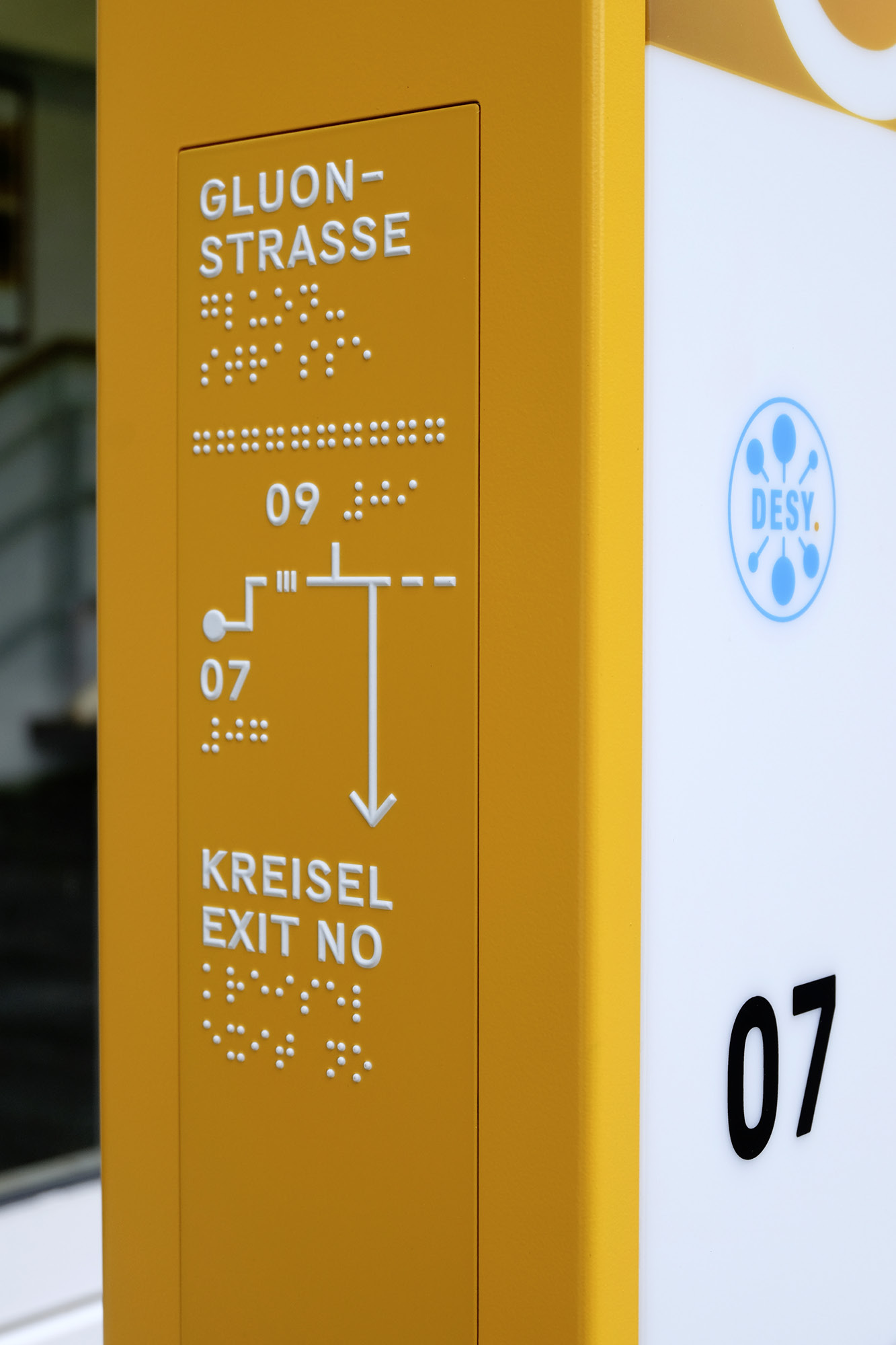 Wegweiser mit taktilem Feld (Plangrafik, Prismenschrift und Braille-Schrift)